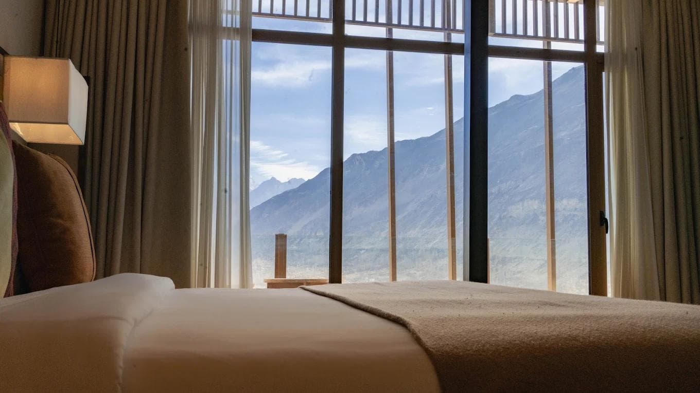 Ambiance Resort Hunza exterior with panoramic mountain views and manicured gardens in Aliabad