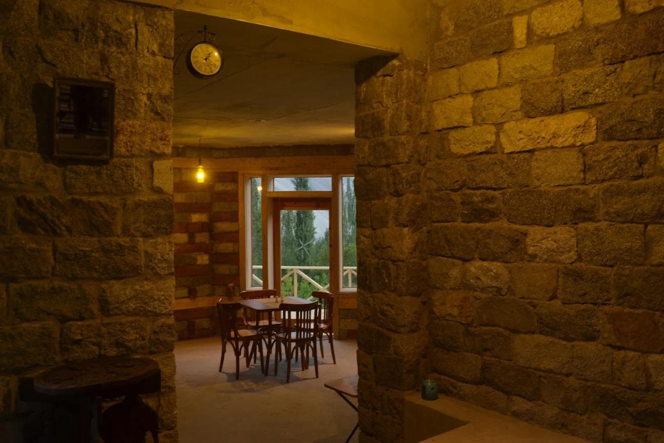Mountain Story Resort Hunza eco lodge surrounded by lush trees in Aliabad with Rakaposhi mountain visible in the distance