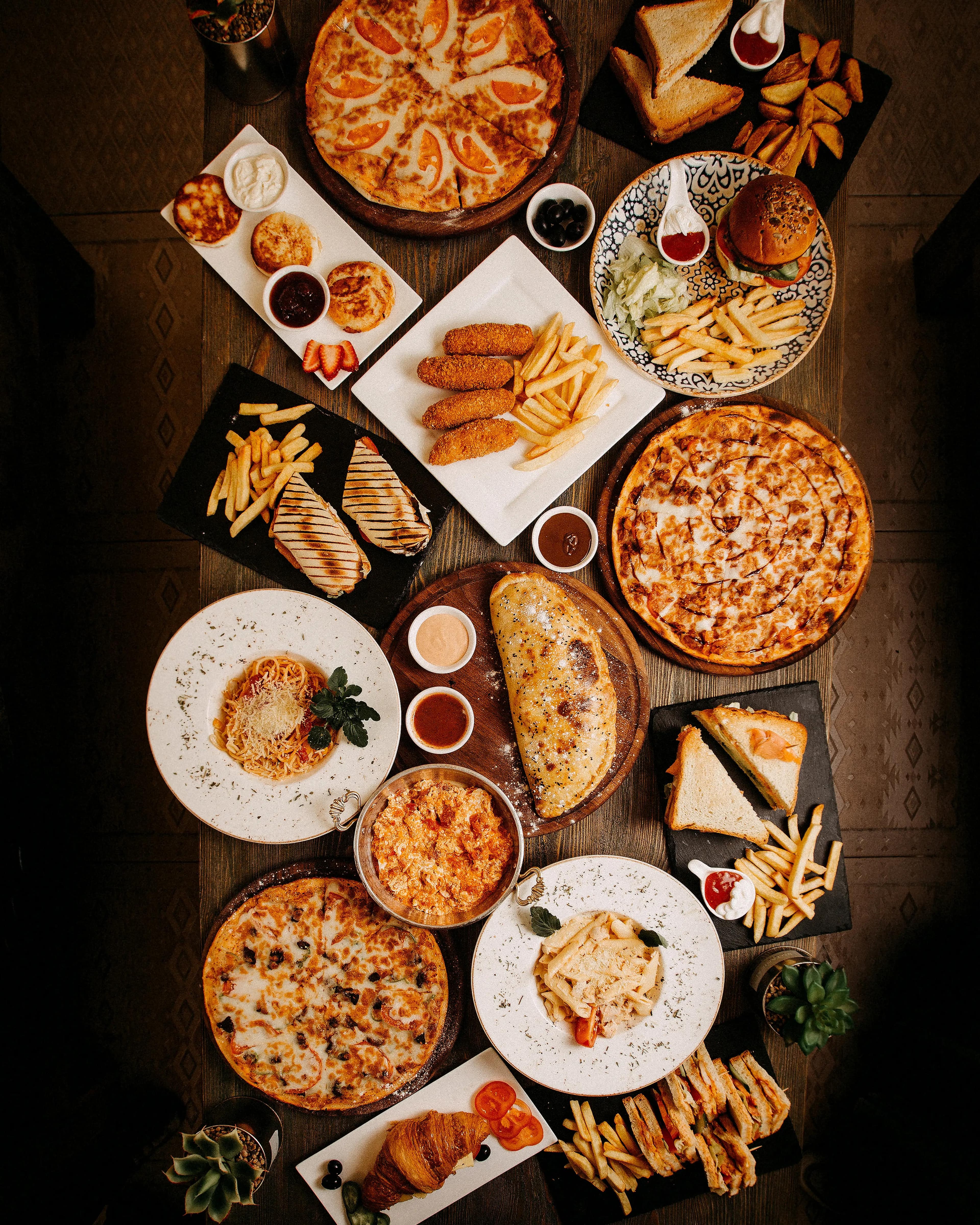 Traditional dishes from Gilgit-Baltistan including chapshuro, mamtu, and kehwa on a wooden table with mountain scenery in the background